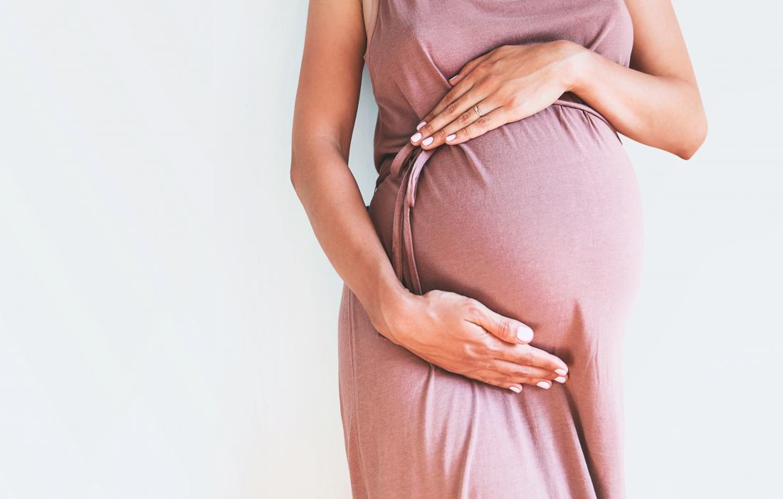 Kobieta w ciąży trzyma dziecko guz.